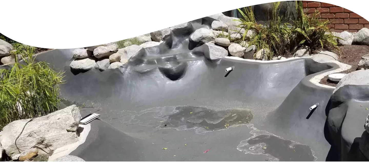 Gray waterproof-coated pond with stone waterfall